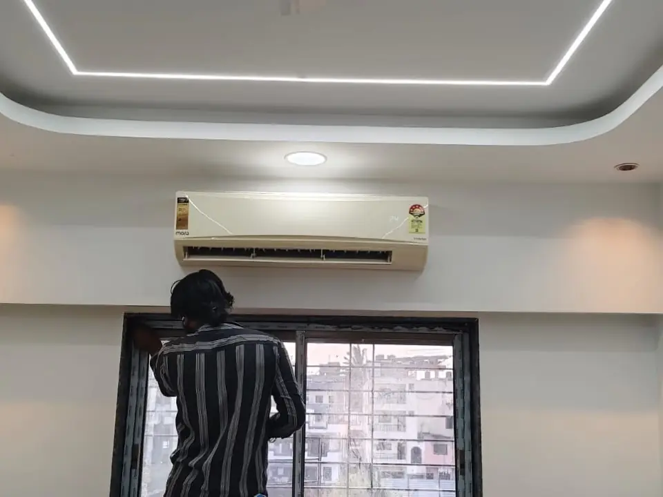 Vikas Cool Wave technician servicing a residential split AC indoor unit in a Pune apartment.